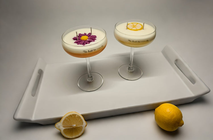 Cocktailvormige geurkaarsen met bloem- en citrusaccenten, stijlvol gepresenteerd op een wit dienblad fris, elegant en zomers van sfeer.