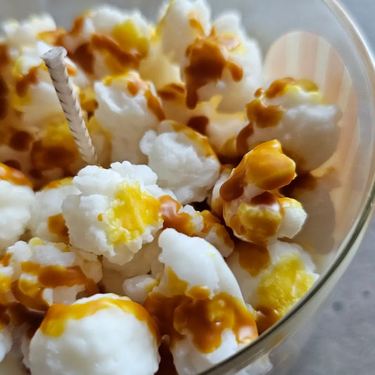 Close-up van popcorn kaars met karamel drizzle realistische waxdetails