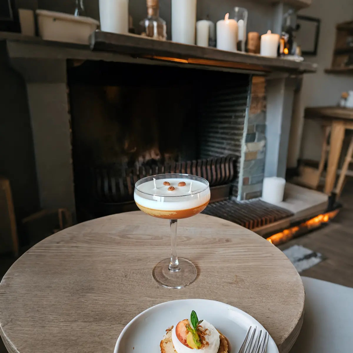 Espresso martini geurkaars op ronde tafel met warm interieur op de achtergrond
