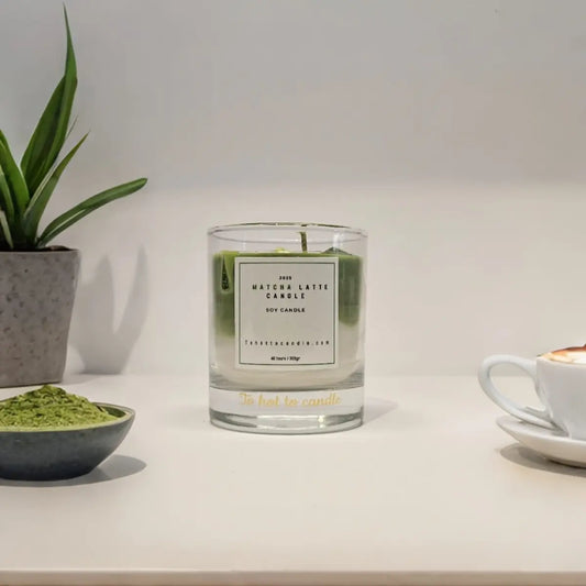 Matcha latte kaars met theelepel en iced matcha op tafel