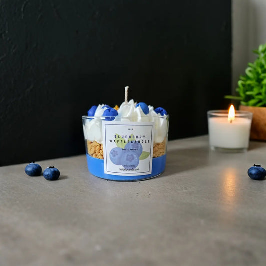 Blauwe sojakaars met blauwe bessen decor en brandend theelichtje in warme setting.