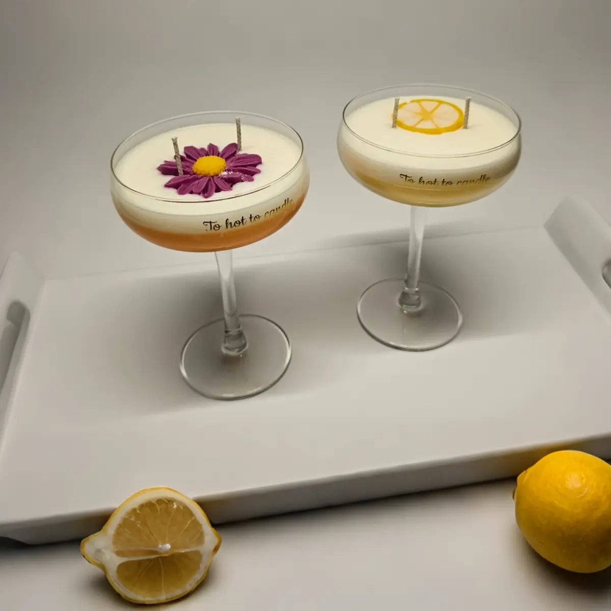 Sfeervolle afbeelding van cocktail-geurkaarsen met citroenaccenten op witte ondergrond