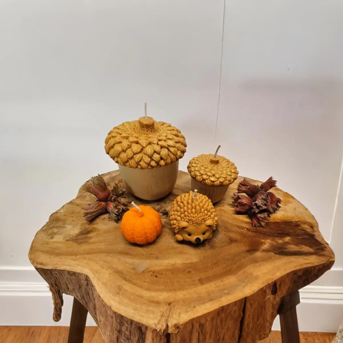 Decoratieve herfst kaarsen set 4-delig pompoen, eikels en egeltje in sfeervolle setting