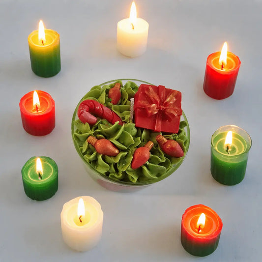 Bovenaanzicht van Grumpy Christmas geurkaars detail van groen-rode kaars in kerststijl omringd door kleine brandende kaarsjes