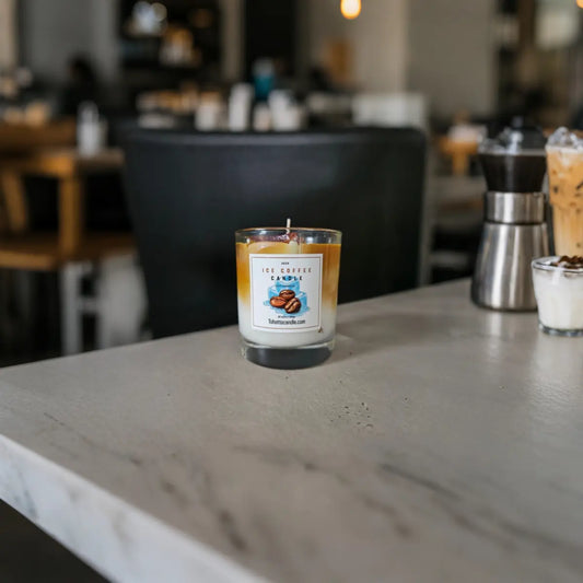 IJskoffie-geïnspireerde kaars met romige kleurlaag op marmeren tafel in café.