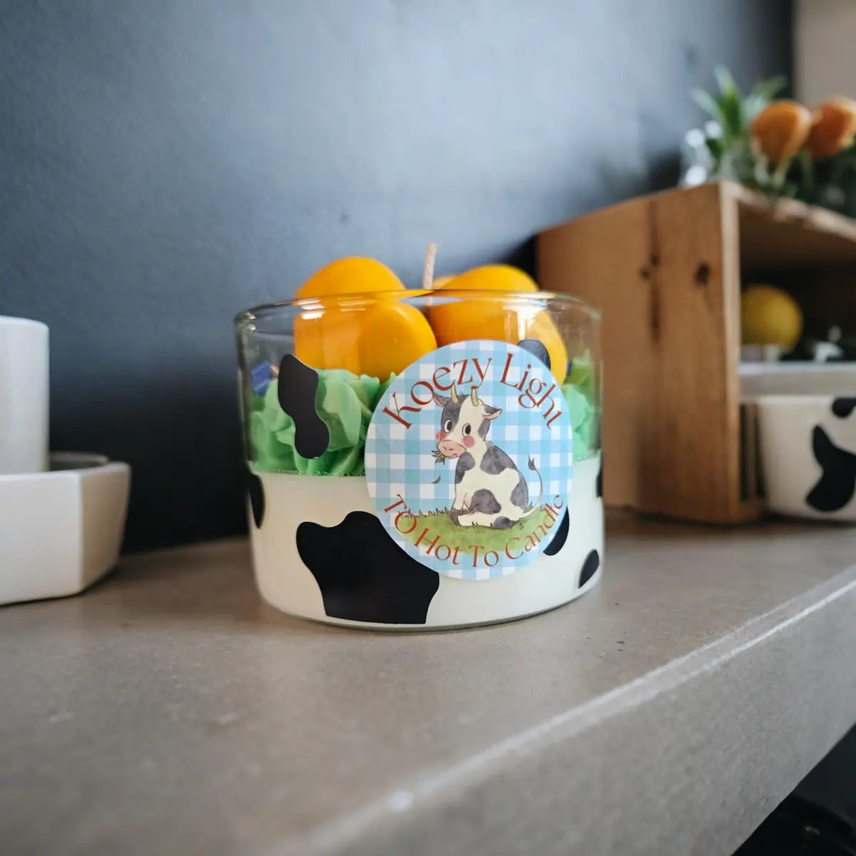 Decoratieve kaars met klompen en zwart-wit koeienmotief, landelijke sfeer